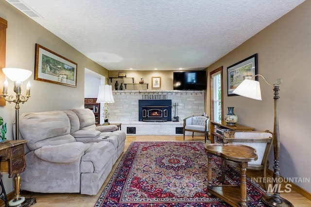 10838 W Southerland St, Boise, ID 83709 - living room with a textured ceiling, a fireplace, wood finished floors, and visible vents