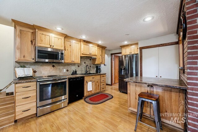 10838 W Southerland St, Boise, ID 83709 - kitchen with dark countertops, tasteful backsplash, black appliances, and light wood-style floors