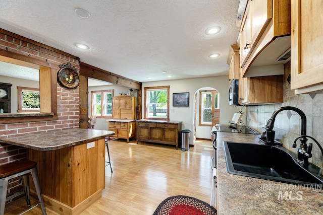 10838 W Southerland St, Boise, ID 83709 - kitchen with a kitchen breakfast bar, a textured ceiling, a sink, and tasteful backsplash