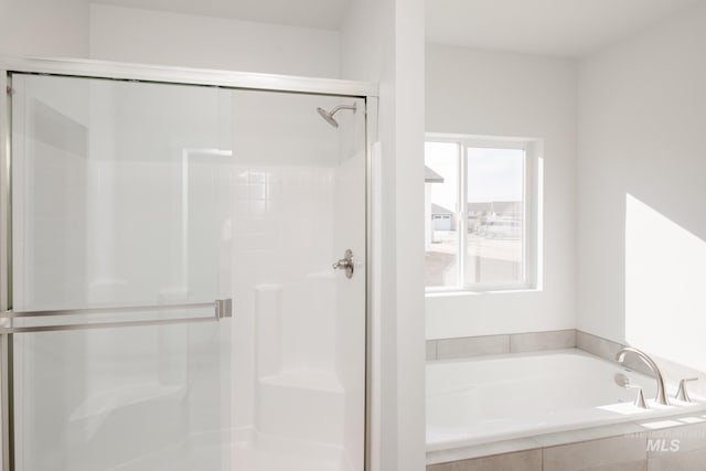 bathroom featuring independent shower and bath