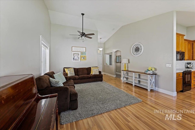 1879 Prairie View Way, Middleton, ID 83644 - living area with ceiling fan, light wood finished floors, baseboards, high vaulted ceiling, and arched walkways