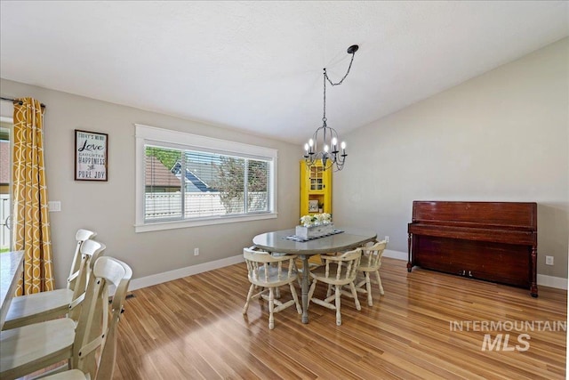 1879 Prairie View Way, Middleton, ID 83644 - dining area with light wood-style flooring, a chandelier, baseboards, and vaulted ceiling