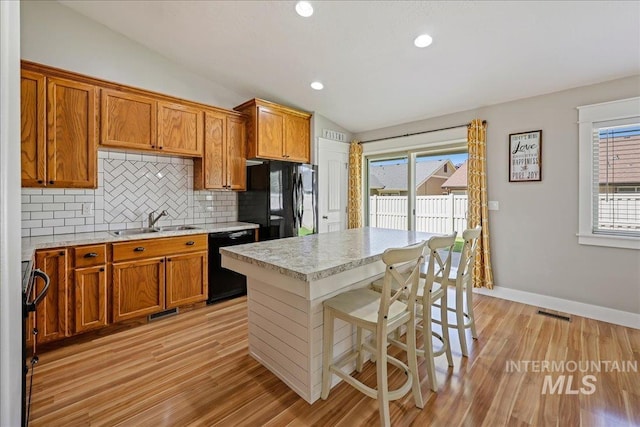 1879 Prairie View Way, Middleton, ID 83644 - kitchen with black appliances, lofted ceiling, a sink, brown cabinetry, and recessed lighting
