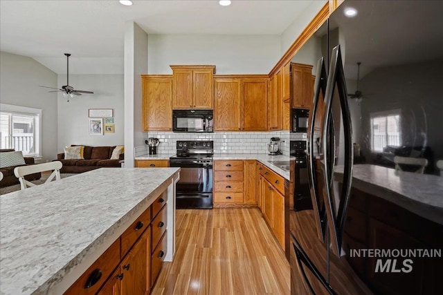1879 Prairie View Way, Middleton, ID 83644 - kitchen with black appliances, a ceiling fan, light wood-style flooring, tasteful backsplash, and light countertops