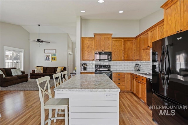 1879 Prairie View Way, Middleton, ID 83644 - kitchen featuring black appliances, light countertops, tasteful backsplash, lofted ceiling, and light wood-type flooring
