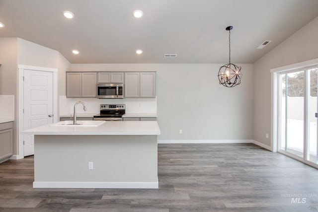 kitchen featuring gray cabinetry, stainless steel appliances, sink, lofted ceiling, and a center island with sink