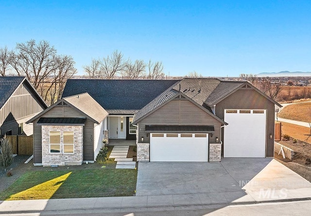 craftsman inspired home with concrete driveway, an attached garage, fence, stone siding, and a front lawn