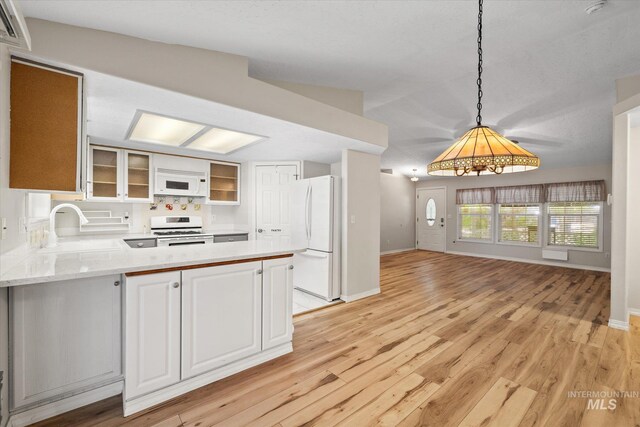 2800 Taylor Ct, Nampa, ID 83686 - kitchen featuring white appliances, a peninsula, light wood-style flooring, glass insert cabinets, and light countertops