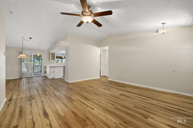 2800 Taylor Ct, Nampa, ID 83686 - unfurnished living room featuring light wood-style flooring, a ceiling fan, and vaulted ceiling