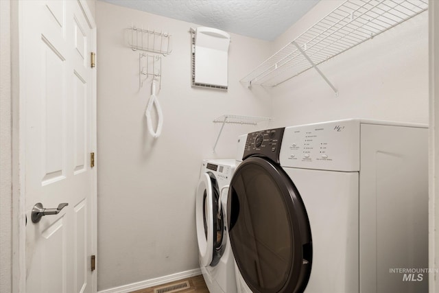 2800 Taylor Ct, Nampa, ID 83686 - laundry room featuring separate washer and dryer, wood finished floors, and a textured ceiling