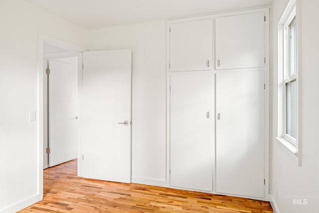 unfurnished bedroom with light hardwood / wood-style floors and a closet