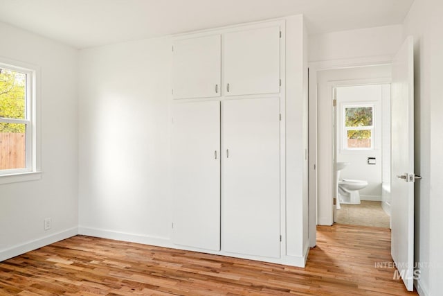 unfurnished bedroom with light wood-type flooring and a closet