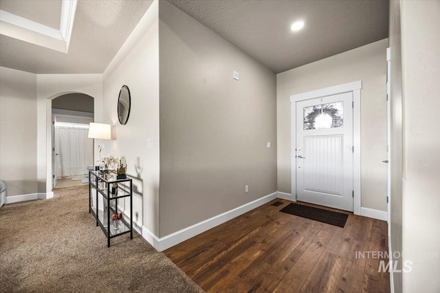 entryway featuring dark wood-type flooring and a textured ceiling