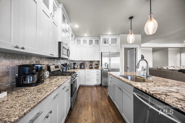 kitchen with decorative light fixtures, decorative backsplash, stainless steel appliances, and white cabinets