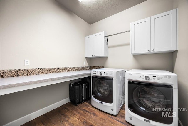 clothes washing area with dark wood-type flooring, cabinets, washing machine and dryer, and a textured ceiling