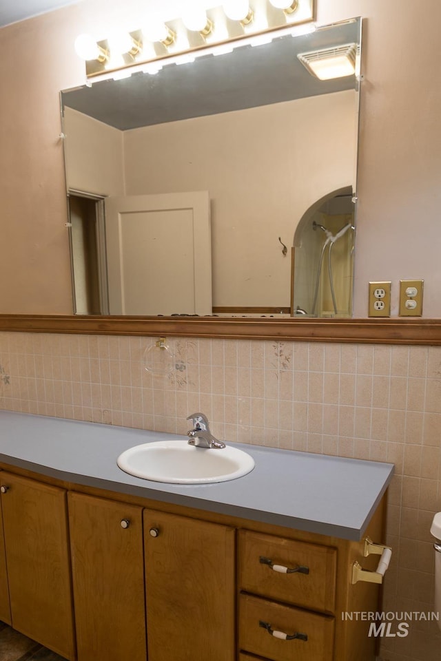 286 SW 3rd Ave, Ontario, OR 97914 - bathroom featuring vanity, tile walls, toilet, and decorative backsplash