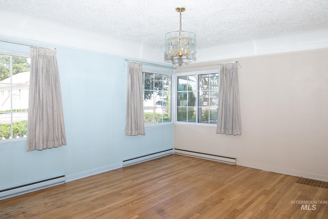286 SW 3rd Ave, Ontario, OR 97914 - unfurnished room with a baseboard radiator, a chandelier, wood finished floors, a textured ceiling, and baseboards