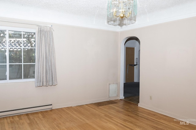 286 SW 3rd Ave, Ontario, OR 97914 - spare room with arched walkways, a baseboard heating unit, wood finished floors, and a chandelier