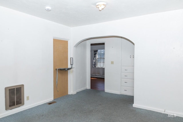 286 SW 3rd Ave, Ontario, OR 97914 - unfurnished room with a baseboard radiator, arched walkways, carpet, heating unit, and baseboards