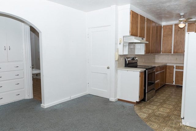 286 SW 3rd Ave, Ontario, OR 97914 - kitchen with stainless steel range with electric stovetop, under cabinet range hood, freestanding refrigerator, arched walkways, and light countertops
