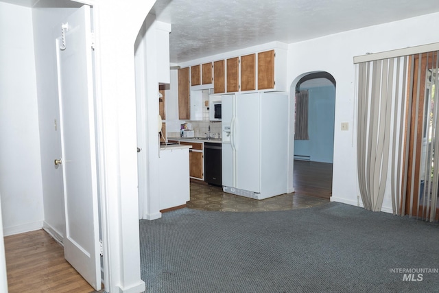 286 SW 3rd Ave, Ontario, OR 97914 - kitchen with arched walkways, white appliances, a baseboard heating unit, light countertops, and brown cabinetry