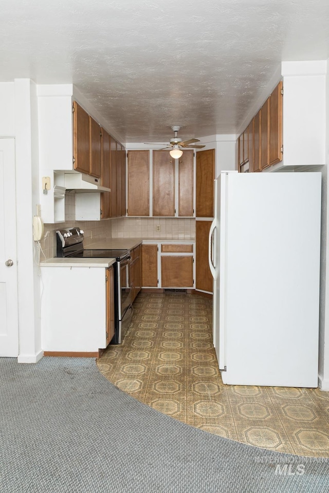 286 SW 3rd Ave, Ontario, OR 97914 - kitchen featuring freestanding refrigerator, stainless steel electric stove, ceiling fan, brown cabinets, and backsplash