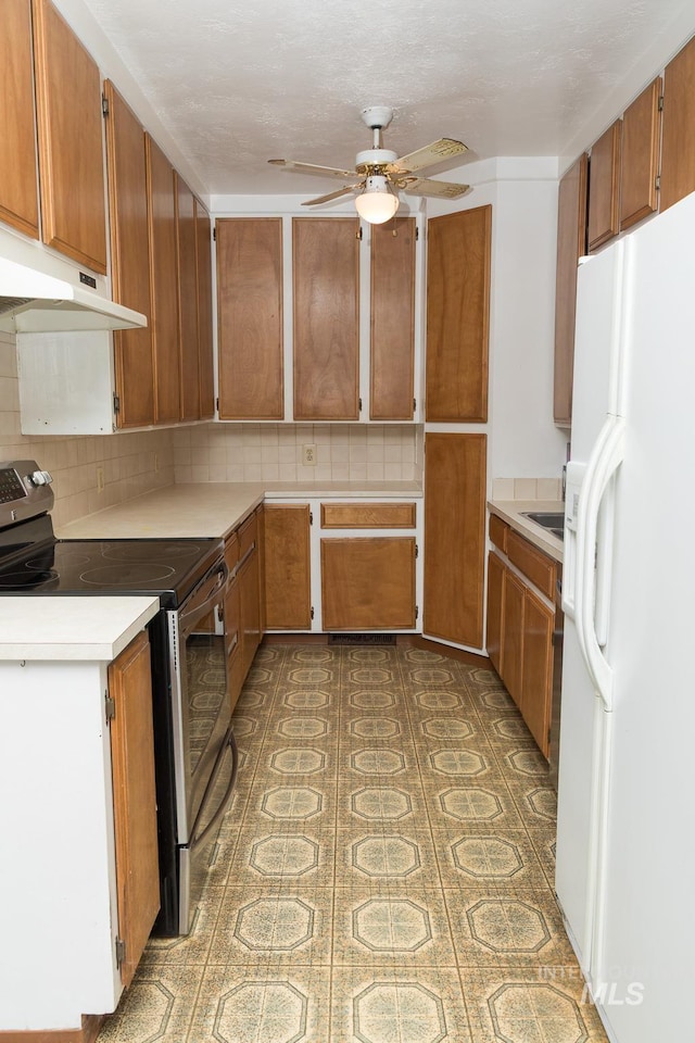 286 SW 3rd Ave, Ontario, OR 97914 - kitchen featuring electric stove, white refrigerator with ice dispenser, ceiling fan, under cabinet range hood, and light countertops
