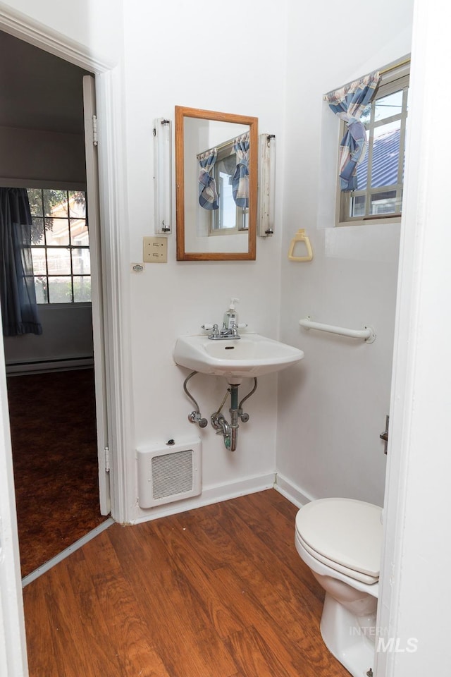 286 SW 3rd Ave, Ontario, OR 97914 - bathroom with wood finished floors, baseboard heating, baseboards, and toilet