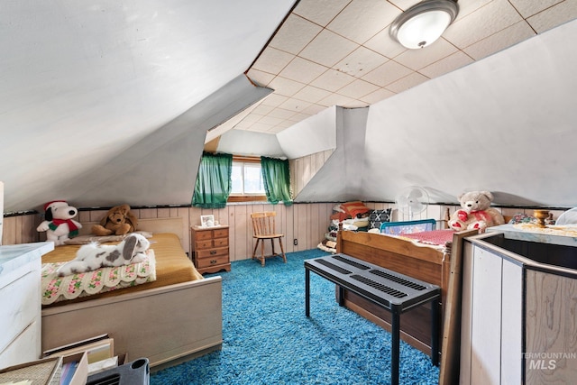 carpeted bedroom featuring vaulted ceiling and wooden walls