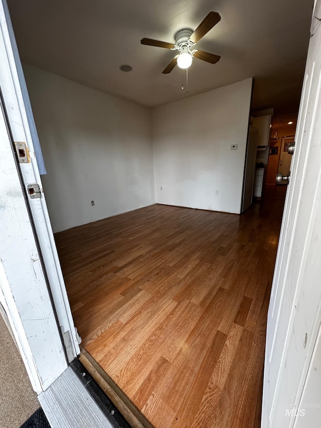 unfurnished room with ceiling fan and dark wood-type flooring