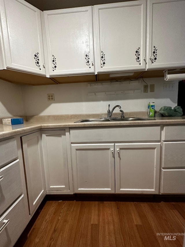 kitchen featuring dark hardwood / wood-style flooring, sink, and white cabinets