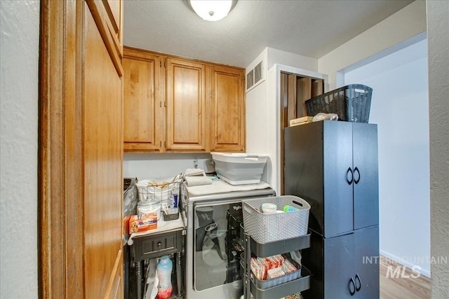 laundry area with visible vents, cabinet space, and separate washer and dryer