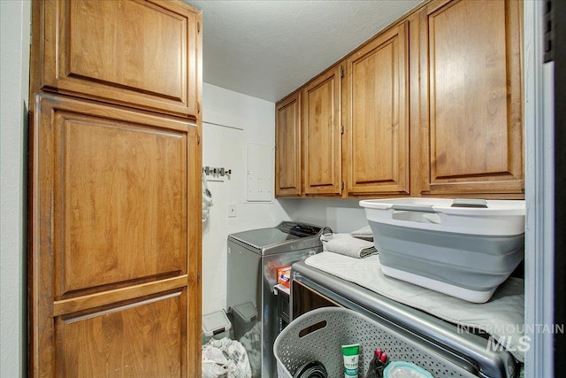 laundry area featuring cabinet space, a textured ceiling, and independent washer and dryer