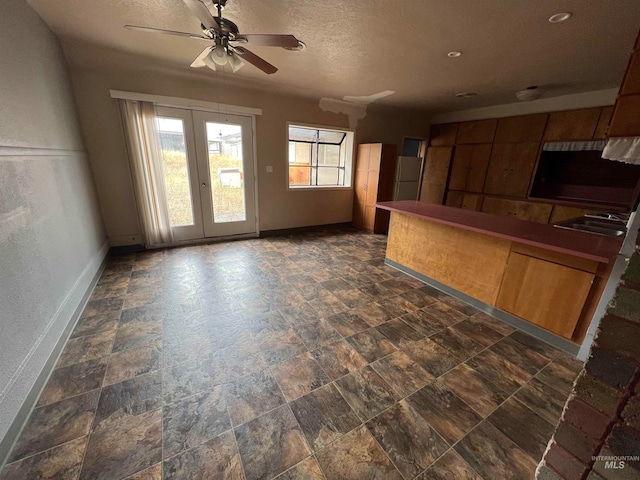 kitchen featuring a textured ceiling, sink, and ceiling fan