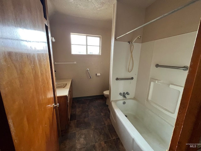 full bathroom featuring vanity, washtub / shower combination, toilet, and a textured ceiling