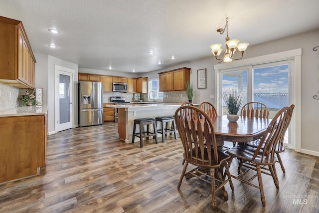 dining area featuring an inviting chandelier, sink, and hardwood / wood-style flooring