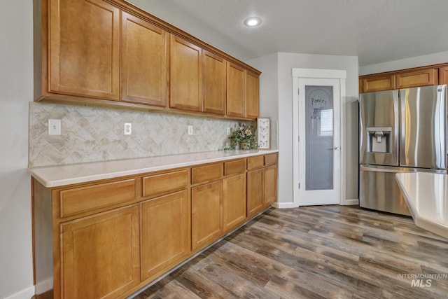 kitchen featuring tasteful backsplash, stainless steel refrigerator with ice dispenser, and dark wood-type flooring