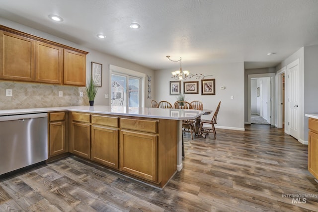 kitchen featuring dishwasher, backsplash, a notable chandelier, dark hardwood / wood-style flooring, and kitchen peninsula