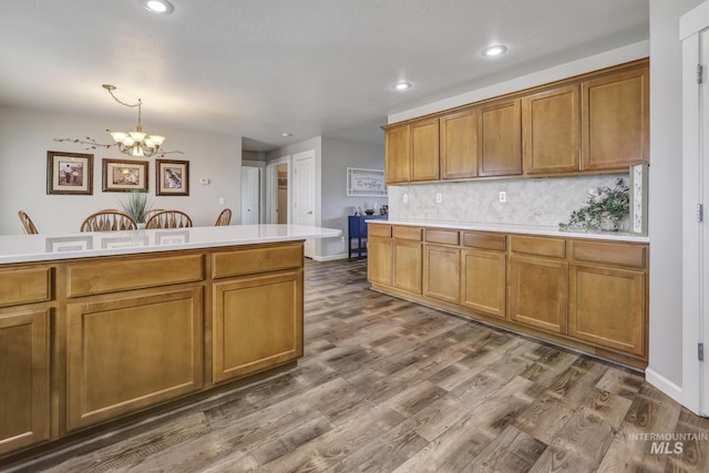 kitchen featuring dark hardwood / wood-style flooring, hanging light fixtures, backsplash, and a chandelier