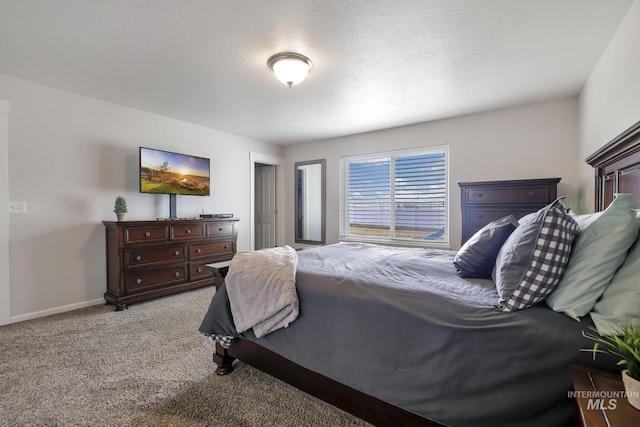 bedroom featuring light colored carpet and a textured ceiling