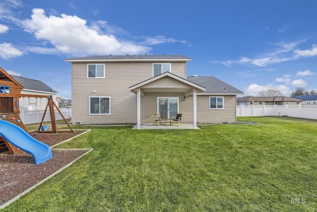 back of house featuring a lawn, a patio, and a playground