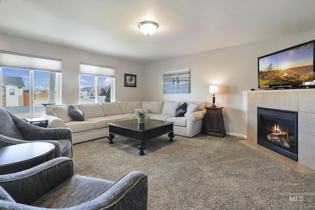 carpeted living room featuring a tile fireplace