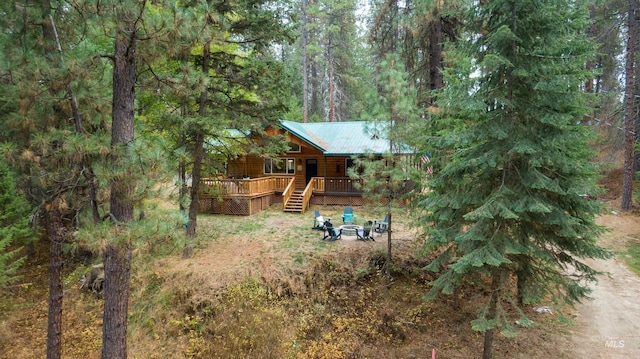 exterior space with a view of trees and a deck