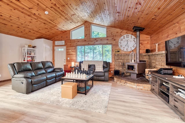 living room featuring high vaulted ceiling, wood finished floors, wooden ceiling, wood walls, and a wood stove