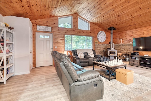 living room featuring high vaulted ceiling, wood finished floors, wooden ceiling, wood walls, and a wood stove