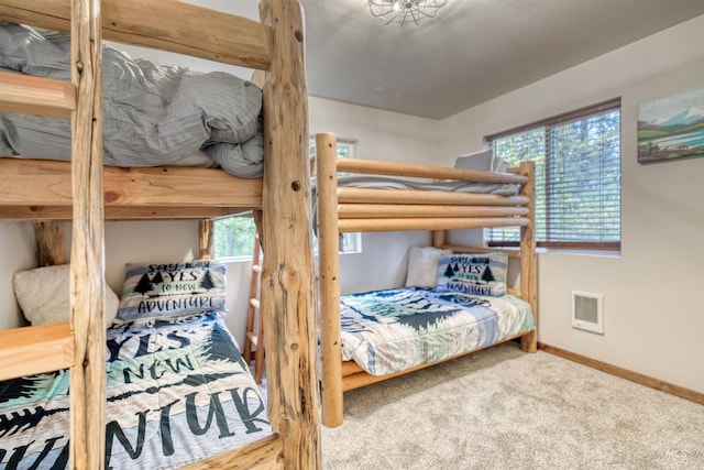 carpeted bedroom featuring visible vents and baseboards