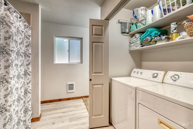 washroom featuring laundry area, baseboards, independent washer and dryer, and light wood finished floors