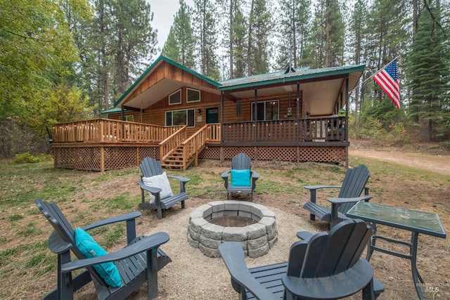 rear view of property with an outdoor fire pit, a deck, and metal roof