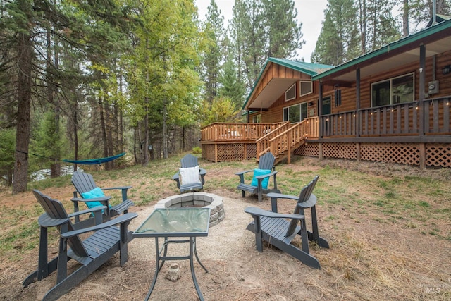 view of yard featuring a deck and a fire pit