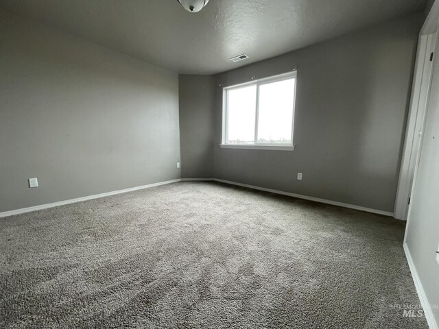 carpeted spare room with baseboards
